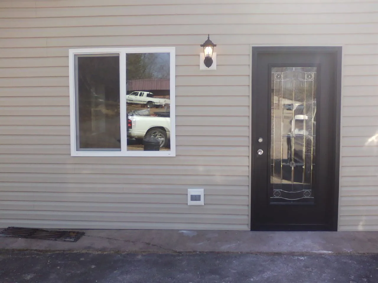New siding, window and entry door on the side of an addition in Austin