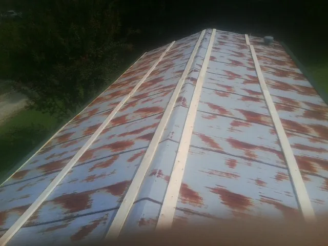 Rusted metal roof panels with new wood purlins before replacement — Storm Damage Roof Repair in Austin by Roofing Brothers